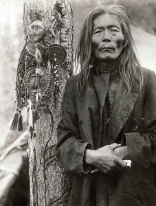 Evenk (Russian minority) shaman with a collection of shamanic objects, including images of helper spirits, early 1900s.